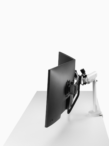 White dual Flo X monitor arm set up with 32'' screens, viewed from the side.