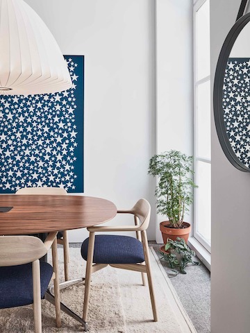 A meeting area in the Paris showroom, featuring wooden Crosshatch chairs around an oval Civic table with a wooden top.