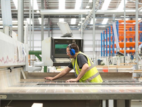 An interior photo of the manufacturing plant at Herman Miller's PortalMill facility, featuring an employee in a safety vest.