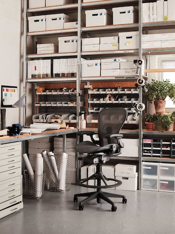 A black Aeron Stool at a workstation.