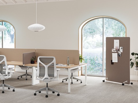 A bright office space with Layout Studio workstations with brown Bound Screens, Cosm Chairs and a brown Bound Mobile Screen in the background.