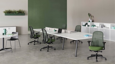 Five black and green Lino Chairs positioned around a large Memo desk. Paragraph units provide storage options around the room with a white Civic Table offering an alternative workspace.