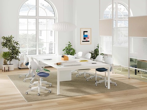 A bright collaborative office space with a Layout Studio meeting table, seating, and a Maars boundary wall.