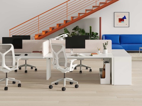 A bright Layout Studio workspace with colourful stairs ascending to the second level and additional ancillary seating in the background.