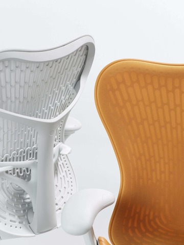 Close up of two Mirra 2 Chairs with a Butterfly back. One in alpine and the other in ochre.