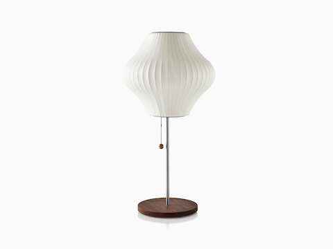 A white Nelson Pear Lotus Table Lamp with a walnut-covered steel base.