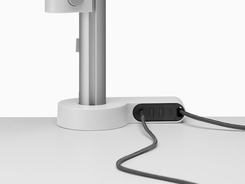 A desk with a power and a data cable connected to an Ondo Connectivity Module.