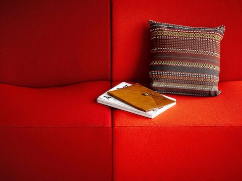 Close view of two Swoop modular seating components in a red fabric.