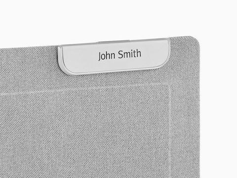 A Ubi Name Tag attached to a fabric-covered panel.
