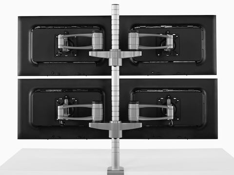 Rear view of four monitors attached to a single Wishbone Monitor Arm post.