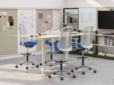 A workshop with cool, calm, refreshing tones and lots of natural light. Swatches are pinned to the boards on the OE1 Wall Rails and at the centre is a standing-height Civic Table with four Lino Stools.