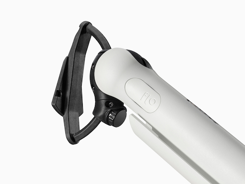 A close-up of a white Flo Single monitor arm with a black D ring.