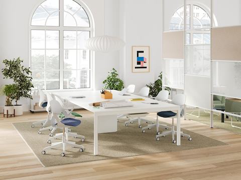 A bright collaborative office space with a Layout Studio meeting table, seating, and a Maars boundary wall.