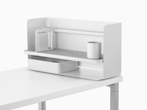 A small white Ubi desktop organiser with a bookend, pencil cup, grey non-skid shelf, and storage box.