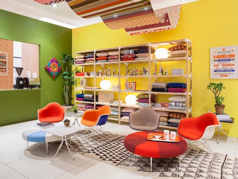 Girard's Color Wheel Ottomans and Eames Upholstered Molded Fiberglass Arm Chairs form the basis of a Girard-inspired living room.