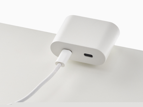 Ello Mini surface clamp USB-C power solution shown in white charging a laptop.