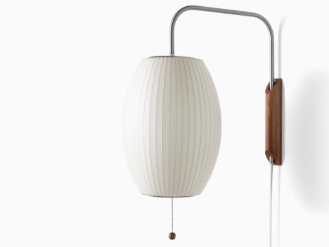 A Nelson Cigar Wall Sconce with a swivel arm and walnut wall mount.