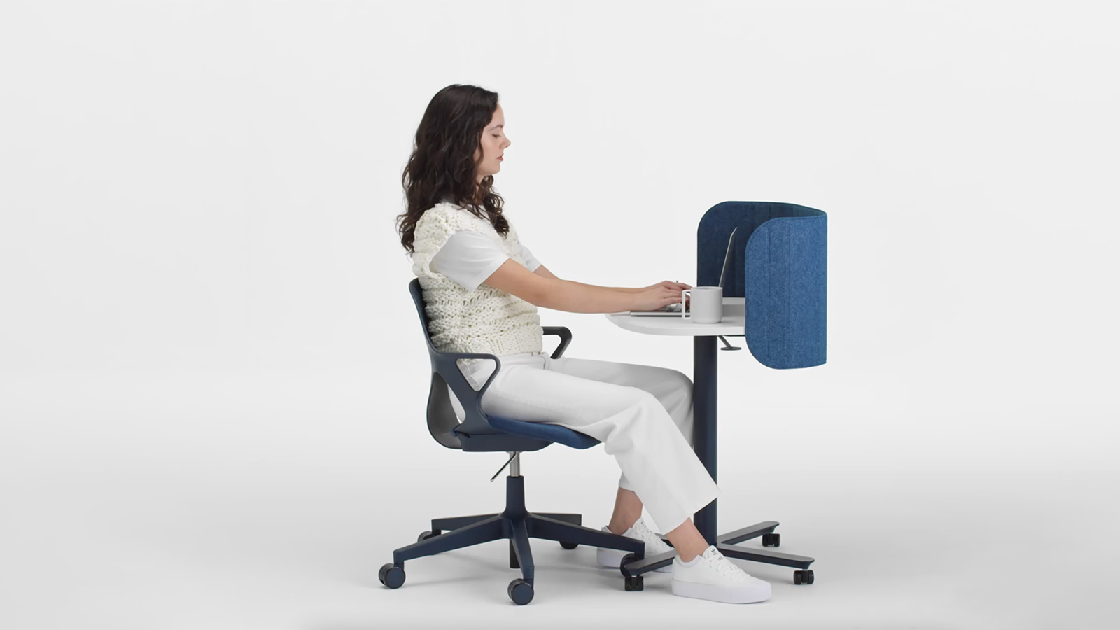 Short video of a woman working at a Passport Work Table and changing postures from seated to standing.