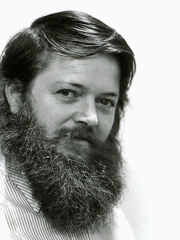 A black and white headshot of designer Ray Wilkes. Viewed at a three-quarter front angle.