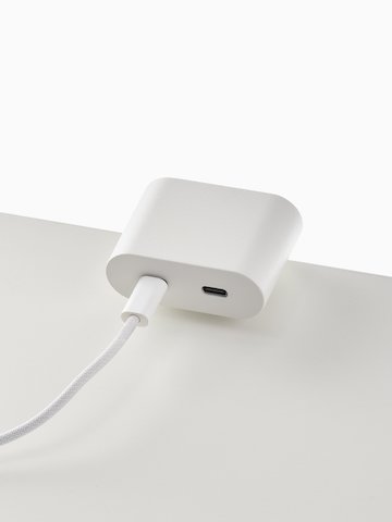 Ello Mini surface clamp USB-C power solution shown in white charging a laptop.