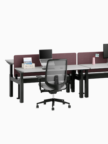 Nevi Link Sit-Stand four-desk configuration in white with grey fabric screens and two desks raised to standing height, Lima Monitor Arms and an Aeron Chair.