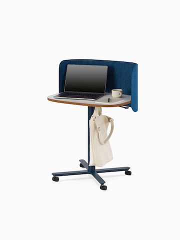 A large Passport Work Table with props, a blue base, a white surface with a plywood edge, a blue screen and a bag hook. Select to go to the Passport Work Table product page.