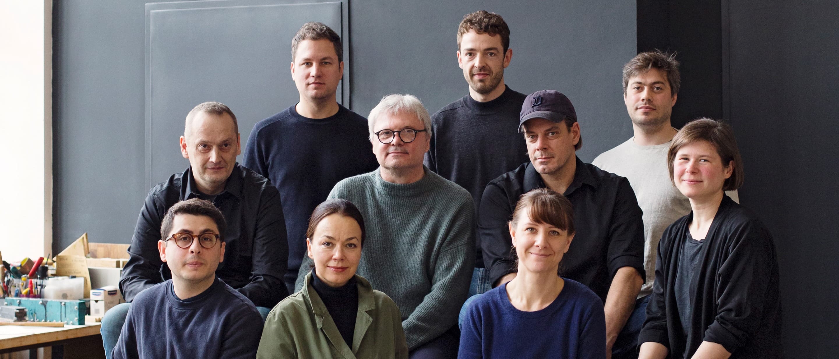 The Studio 7.5 design team sitting together in a group on benches in their studio.