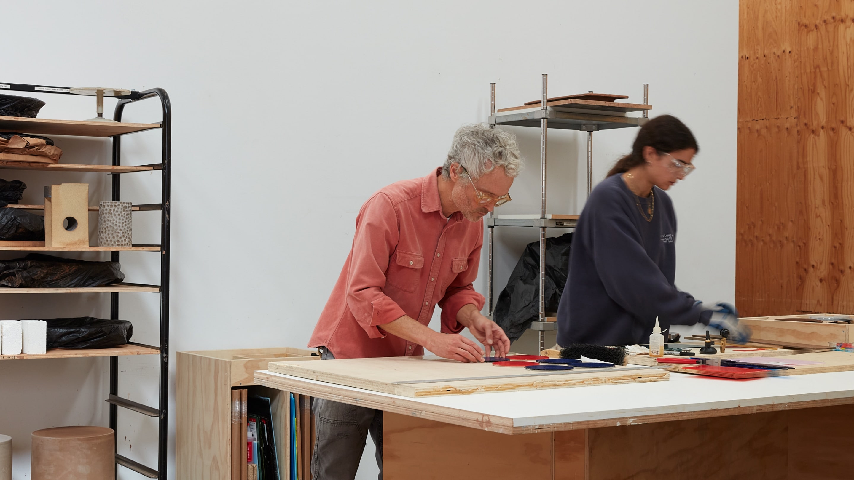 Jesse Schlesinger working with a colleague at a table in his studio.